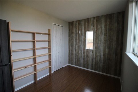 寝室/部屋のアクセントに、ダークなビンテージウッド調の壁紙を一面だけ貼りました。本棚はオーダーメイドです。