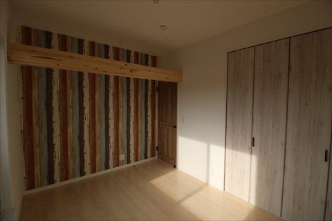子供部屋1/床板はホワイトオーク。壁の1面には、部屋のアクセントとしてビンテージ風の壁紙を貼りました。出入り口のドアの色はナチュラルウォークです。