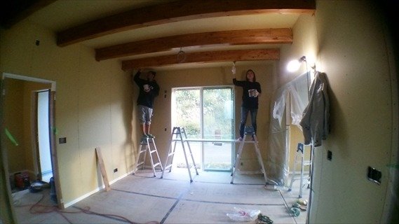 施主様ご夫婦で化粧の梁を塗装中。